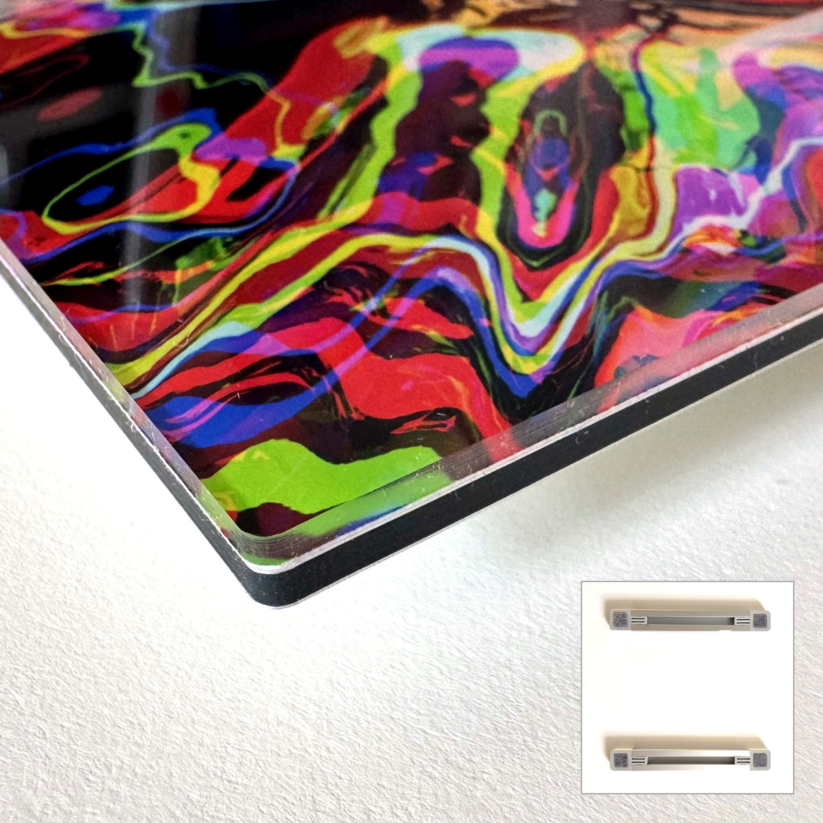 Die klare Kante eines Acrylglas-Drucks auf schwarzem Träger, daneben beide Aufhängeschienen aus Aluminium
