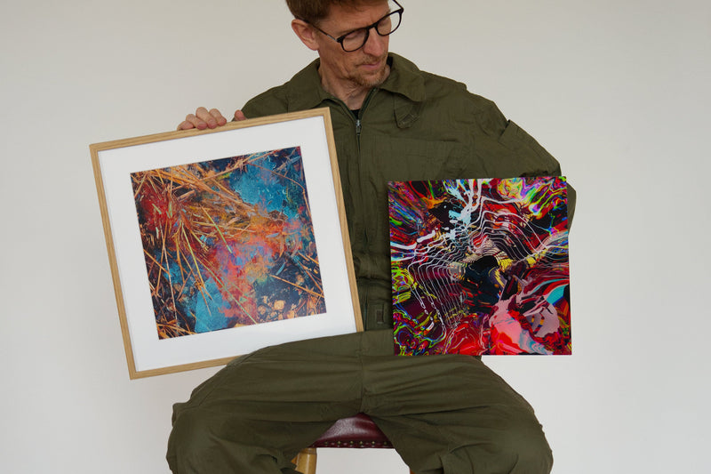 Sascha Markus Huth mit zwei Drucken, einer gerahmt hinter Passepartout, einer ungerahmt